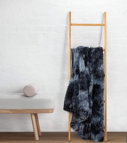 Navy faux fur shaggy throw blanket on wooden ladder, showcasing plush textures for cozy home decor.