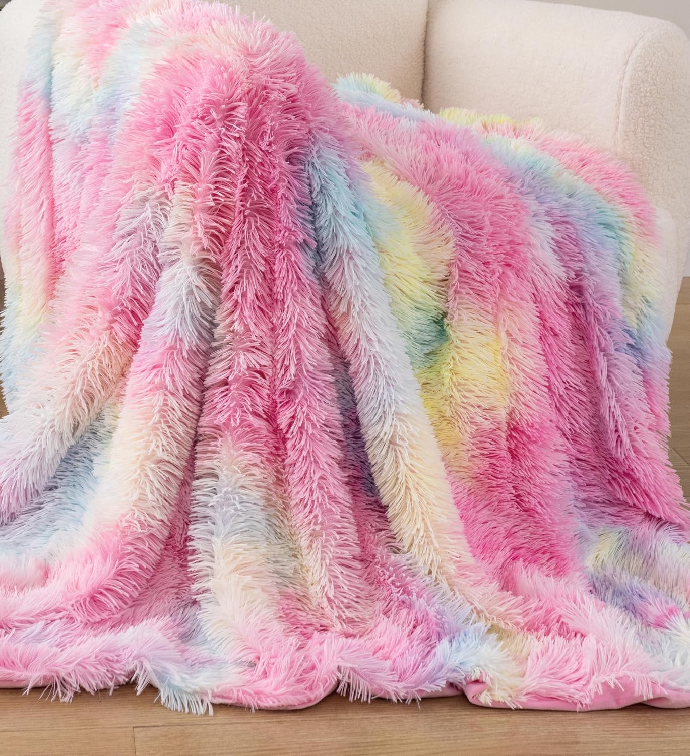 Premium rainbow faux fur shaggy throw blanket draped over a chair, showcasing vibrant colors and soft textures. Perfect for cozy retreats.