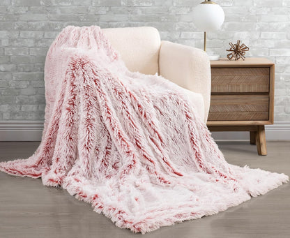 Rose faux fur throw blanket draped over a chair, showcasing plush double-sided texture. Perfect cozy addition to any home decor.