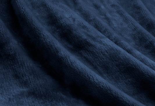 Deep navy plush velvet fabric of a luxurious throw blanket, showcasing its soft texture and elegance.