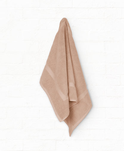 Peach cotton bath towel hanging on wall from St. Regis 7-piece luxury collection