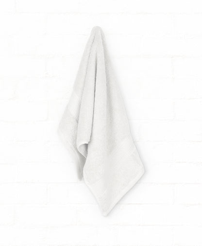 White cotton bath towel from the St. Regis 7-piece luxury collection, hanging on a white wall, ideal for elegant bathroom decor.