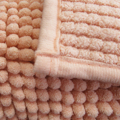 Close-up of soft chenille bath mat in peach, showcasing its plush texture and cozy design for bathroom comfort.