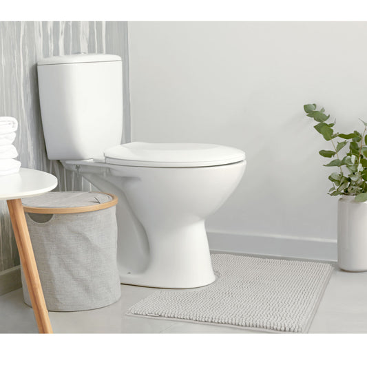 Stylish bathroom setting featuring a gray bath mat, toilet, and modern decor elements for a chic look.