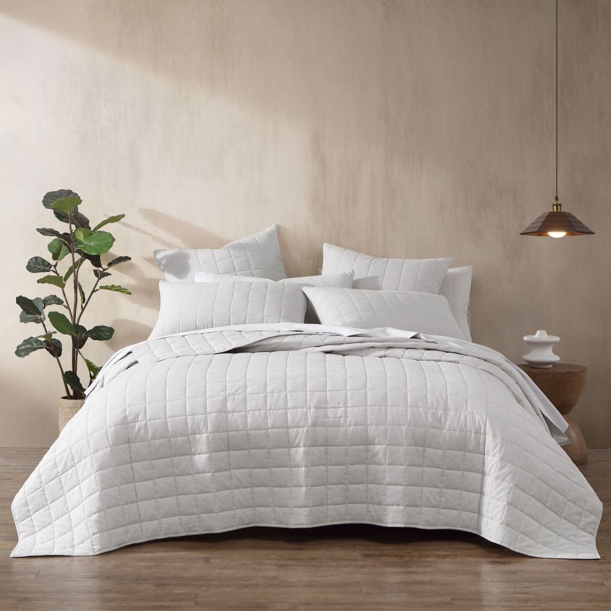 Contemporary white quilt cover set on a bed, showcasing box quilting design with decorative pillows and serene decor.