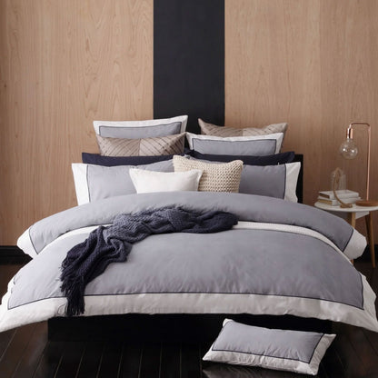 Logan and Mason Essex Navy Cotton-rich Percale Quilt Cover Set with herringbone pattern and white border on bed.