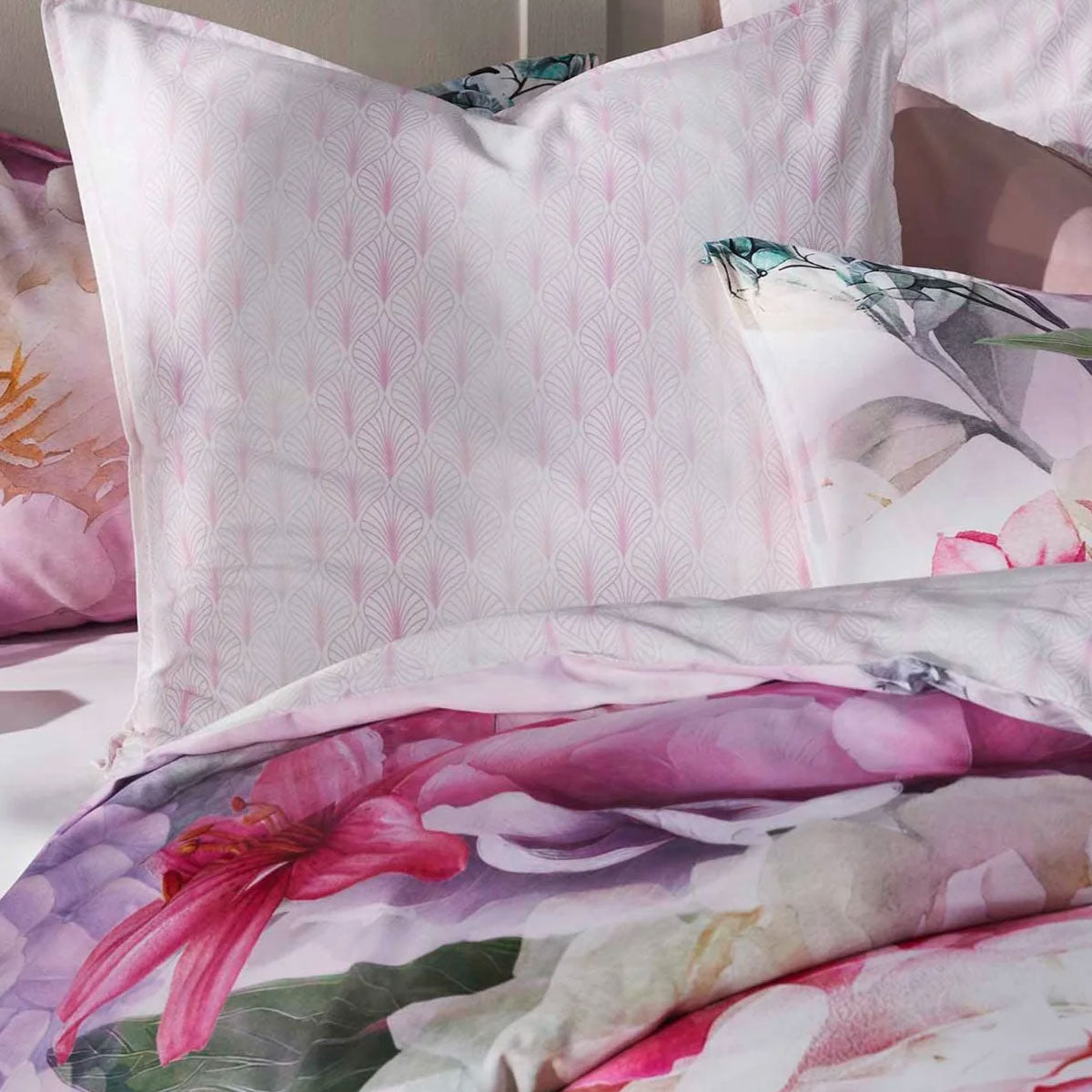 Logan and Mason pink floral quilt cover set with decorative pillows, showcasing vibrant patterns and soft cotton texture.