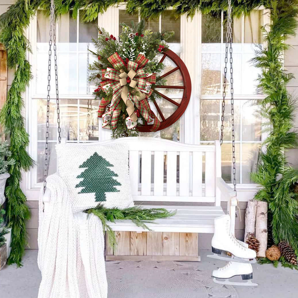 Festive Christmas Red Wooden Wheel Wreath displayed on a swing, surrounded by greenery and holiday decor.