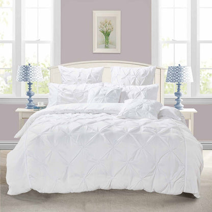 Elegant white diamond pintuck quilt cover set on a bed with matching pillows, enhancing bedroom decor and comfort.