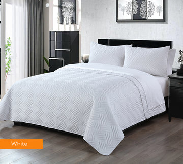 Embossed white comforter set on a king bed, featuring two pillowcases and elegant lightweight design for all seasons.