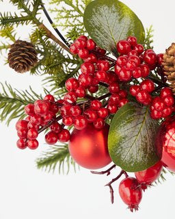 Close-up of a festive Christmas wreath featuring red berries, shiny ornaments, and greenery, perfect for Aussie Xmas decorations.