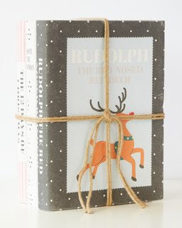 Childrens Christmas book stack featuring "Rudolph the Red-Nosed Reindeer," wrapped in twine, perfect for festive decor.