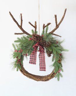 Rustic deer antler wreath with pine, berries, and plaid ribbon, perfect for festive Christmas decor.