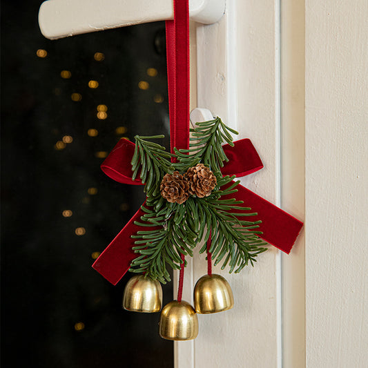 Christmas door ornament with pinecones, golden bells, and red ribbon for festive holiday decor.