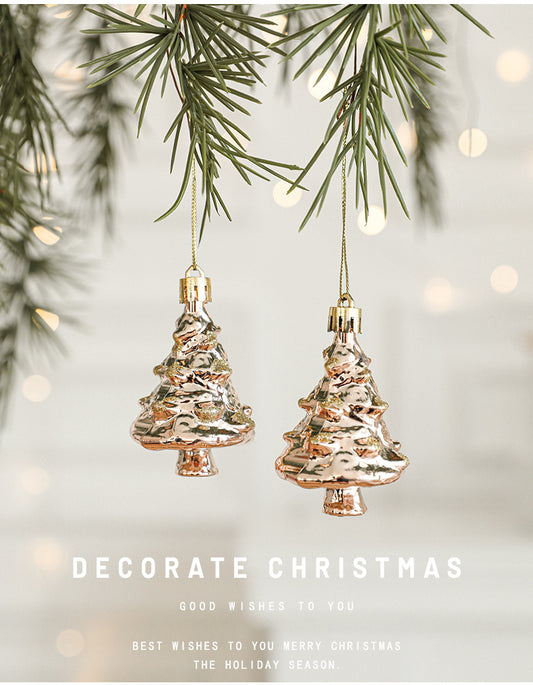 Set of rose gold Christmas tree ornaments hanging among festive greenery for holiday decoration.