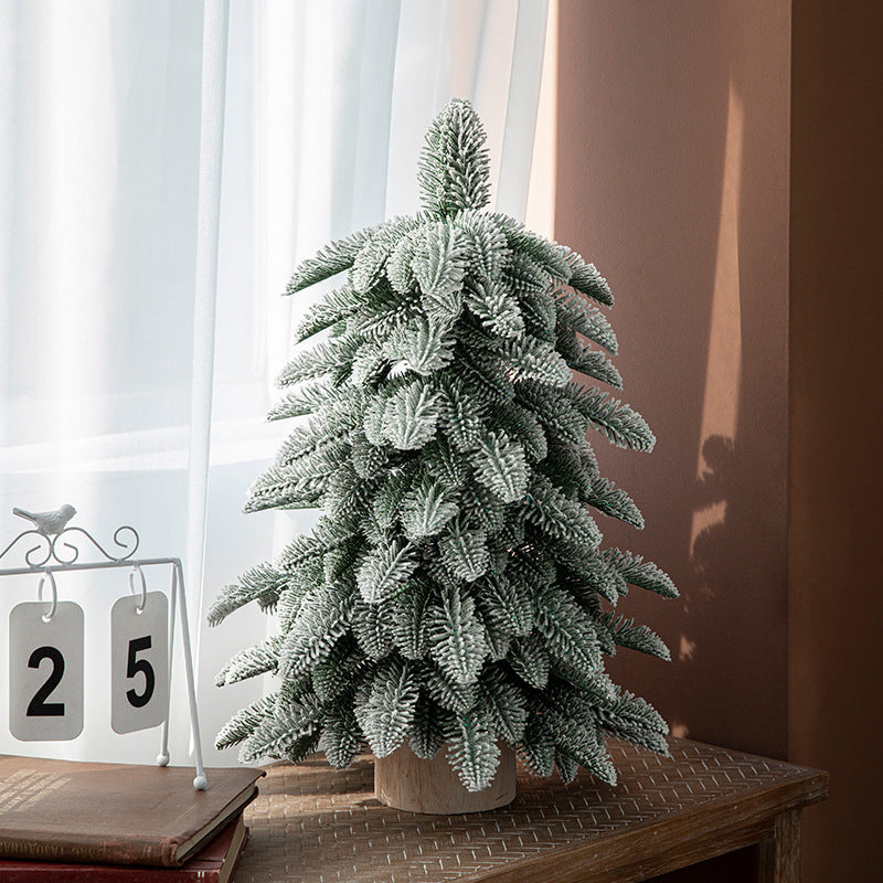 Frosted 55cm mini Christmas tree with snow-covered branches, ideal for festive indoor decoration in small spaces.