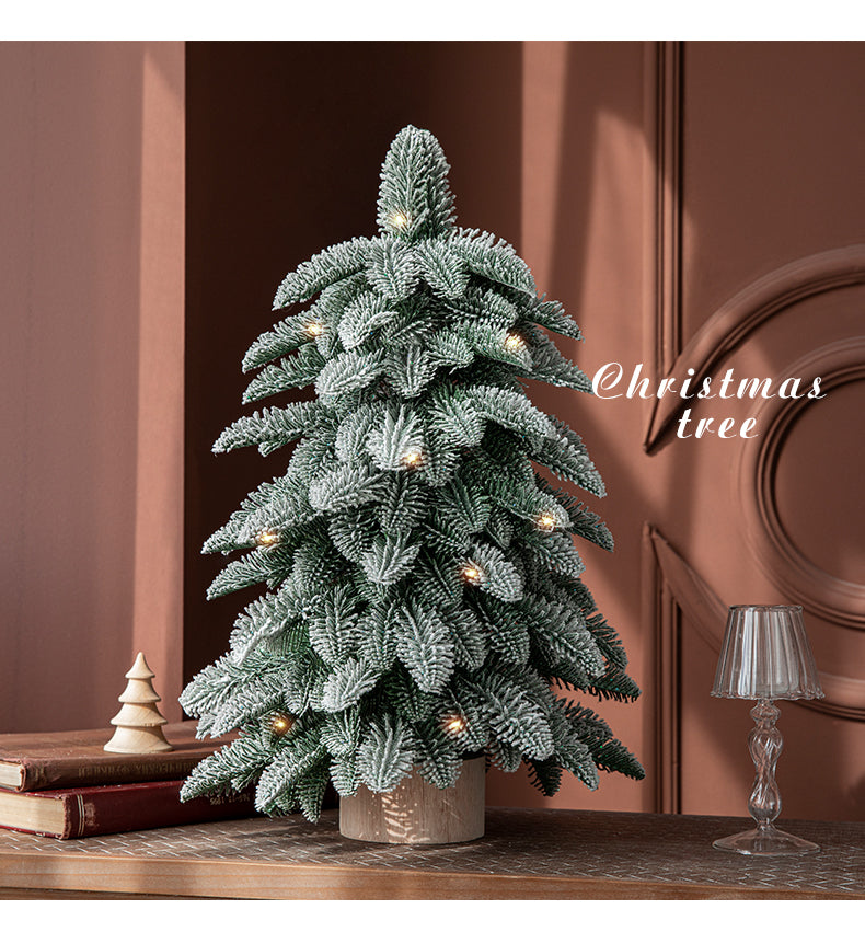 Frosted mini Christmas tree with snow-covered branches, perfect for festive indoor decoration in small spaces.