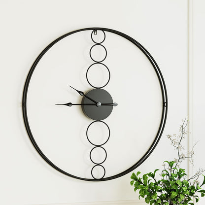 Large black wall clock with minimalist design and no numerals, perfect for modern interiors and office spaces.