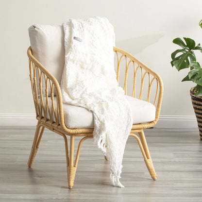 White Alysian washed cotton textured throw blanket draped over a stylish chair, perfect for cozying up any living space.